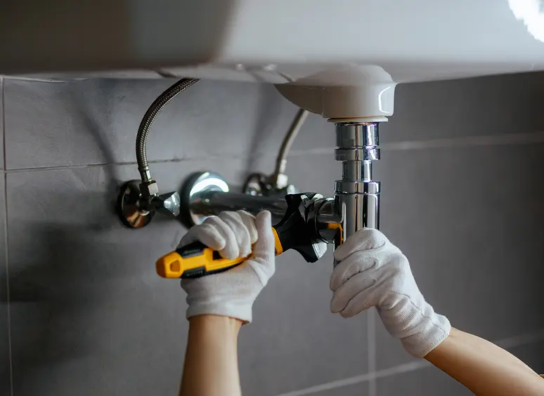 Hands repairing under-sink pipe