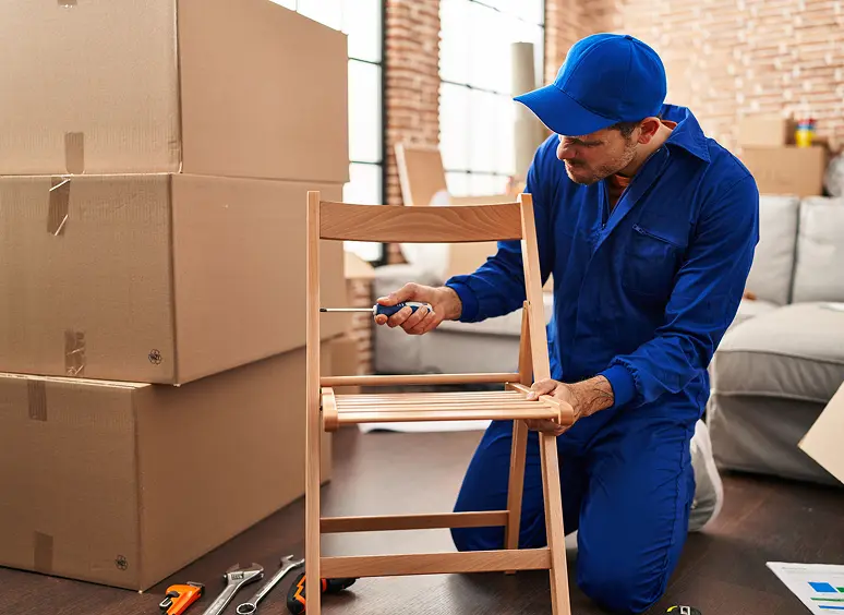 Person building chair near moving boxes