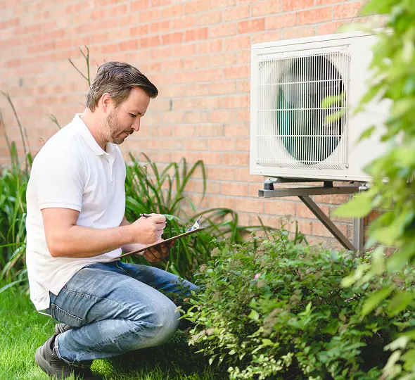 Man inspecting outdoor air conditioning unit