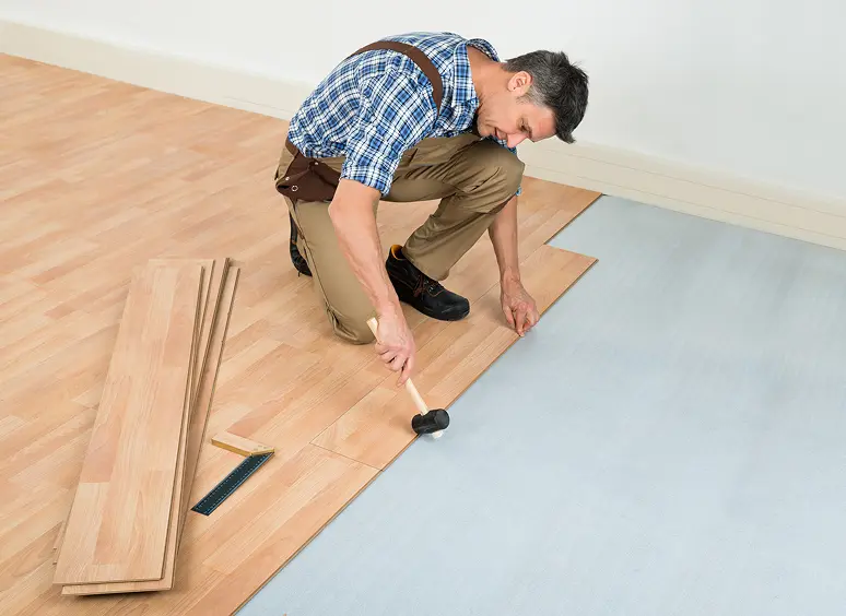 Worker laying laminate floor panels