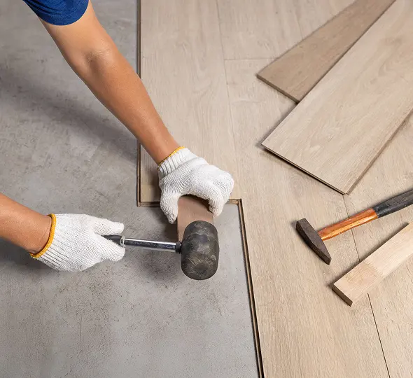 Worker aligning wooden floor panels